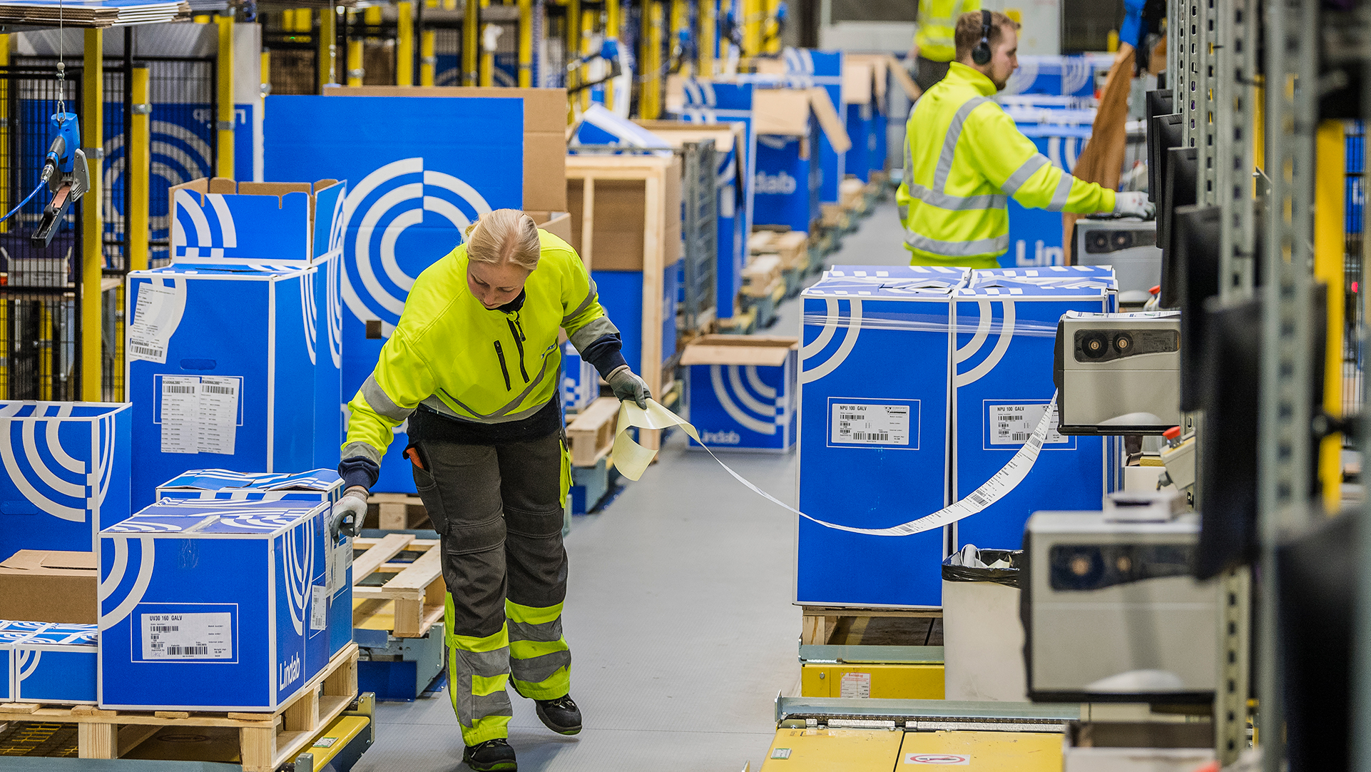 Lindabin työntekijä laittaa tuotetarroja pakkauslaatikoihin