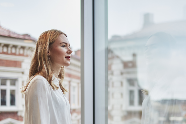 Woman standing by the window with phone Indoor air environment photo shoot session Aura