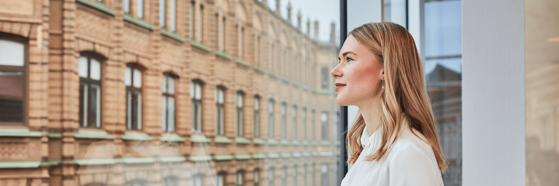 Nainen katsoo ikkunasta ulos